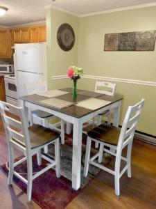a white table and chairs with a vase of flowers on it at Cozy condo. Full resort access. Great for couples and families. in Claysburg