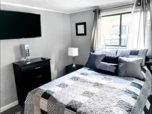 1 dormitorio con 1 cama y TV en la pared en Cozy condo. Full resort access. Great for couples and families., en Claysburg