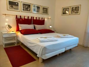 a bedroom with a large white bed with red pillows at Corte del Fuin in Seregno