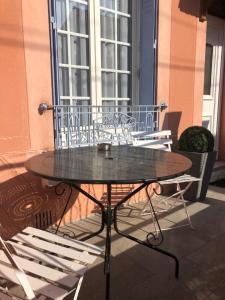 une table en verre et deux chaises sur la terrasse dans l'établissement Villa Liberté, à Villejuif