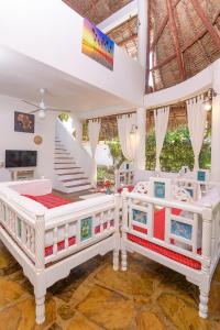two beds in a room with a staircase at Minimi Couzy villa casaurina in Malindi +22 photos