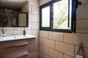 a bathroom with a sink and a window at El Cedro Cottage Home in Hermigua