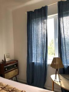 a bedroom with a blue curtain and a window at Hillside country house - Long stays in Vilnius