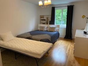 1 dormitorio con cama, sofá y ventana en Fin lägenhet. Gångavstånd till Strömstads centrum. en Strömstad