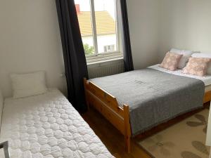 um quarto com 2 camas e uma janela em Fin lägenhet. Gångavstånd till Strömstads centrum. em Strömstad