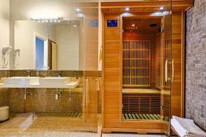 La salle de bains est pourvue d'une douche en verre et d'un lavabo. dans l'établissement Le Suite, à Polistena