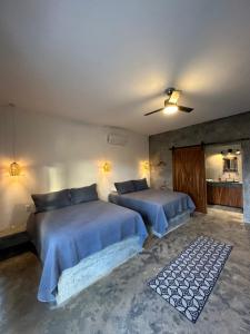 a bedroom with two beds and a ceiling fan at Villas Del Scarlet Cardones in Pescadero