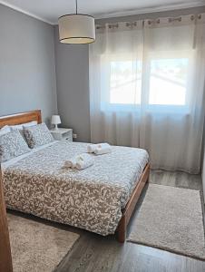 een slaapkamer met een bed met twee handdoeken erop bij House da Didy in São João da Pesqueira