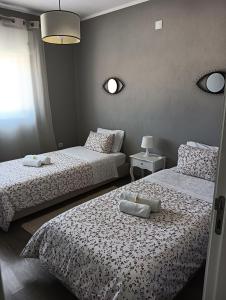 1 dormitorio con 2 camas con sábanas blancas y ventana en House da Didy, en São João da Pesqueira