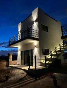 a large white building with a balcony at night at Villas Del Scarlet Cardones in Pescadero