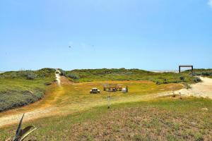 a field with a house on top of a hill at Beachgate Condo Suites and Hotel 437 condo in Port Aransas +3 photos