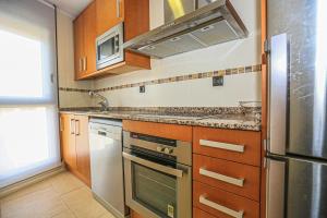 uma cozinha com um lavatório e um fogão forno superior em Di Mare Litoral Costa Dorada - ONLY FAMILIES em Mont-roig del Camp