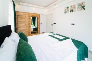 ein Schlafzimmer mit einem weißen Bett mit grüner Bettwäsche in der Unterkunft Villa Ruya by Sakina Escapes in Fethiye