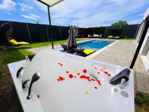 a sink with red petals on it next to a pool at Villa Ruya by Sakina Escapes in Fethiye