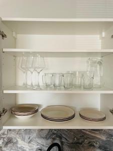 a shelf with plates and glasses on it at Apartmány Andělská in Olomouc
