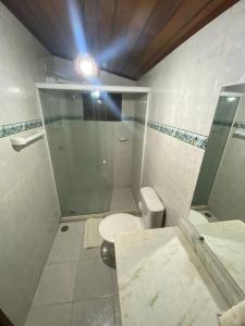 a white bathroom with a shower and a toilet at Pousada Barra Vento in Morro de São Paulo