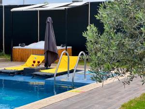 a swimming pool with yellow chairs and an umbrella at Villa Ruya by Sakina Escapes in Fethiye