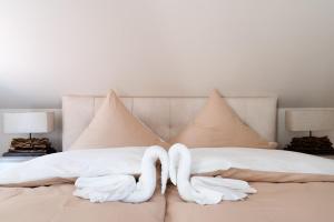 two swans towels are folded on a bed at Waldhotel und Restaurant Zeitreise in Bramsche