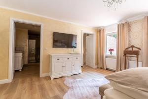 a bedroom with a bed and a television on a wall at Waldhotel und Restaurant Zeitreise in Bramsche +37 photos