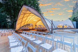 een tent met witte stoelen en een grote tent bij Waldhotel und Restaurant Zeitreise in Bramsche