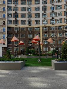 a large building with red umbrellas in front of it at Sunday Hotel in Odesa +38 photos