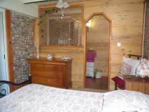 sypialnia z łóżkiem i drewnianą ścianą w obiekcie Chez Jean Marc et Corinne w mieście Priay