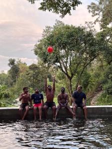 a group of men sitting in the water playing with a red ball at Qatsyir Horizon in Varagampadi