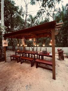 a group of picnic tables under a pavilion with lights at Bodhi Beach House Kannur in Kannur