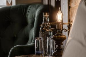 una mesa con una lámpara y gafas en un sofá en Hani i Xheblatit en Berat