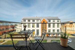 a balcony with two chairs and a table and buildings at King Mindaugas Apartments in Kaunas