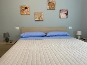 a bedroom with a large bed with blue pillows at MyCosmoStudio - Fiera in Pero