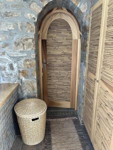 a wooden door in a stone building with a trash can at Ines’s Dream in Stelida