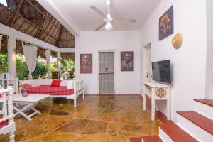 a living room with a couch and a tv at Minimi Couzy villa casaurina in Malindi