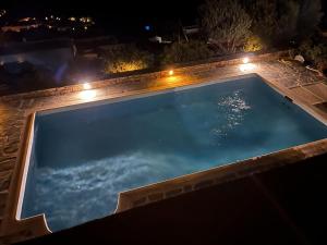 una piscina vacía por la noche con luces en Ines’s Dream en Stelida