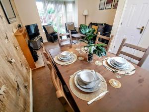 a dining room table with plates and dishes on it at No 23- Large Spacious 3 Bed Home - Parking & WiFi in Nantwich