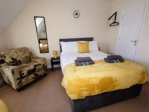 a bedroom with a large bed and a chair at No 23- Large Spacious 3 Bed Home - Parking & WiFi in Nantwich