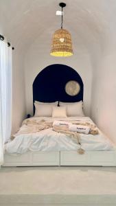 a white bed with a black headboard and a chandelier at Zina Apartment à Sidi Bou Saïd in Sidi Bou Saïd