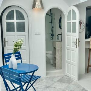 a blue table and chairs in a kitchen with a door at Zina Apartment à Sidi Bou Saïd in Sidi Bou Saïd