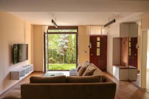 een woonkamer met een bank en een groot raam bij Green Oasis in the City Center in Pristina