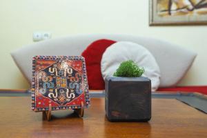 AM Apartments 1 في يريفان: طاولة مع نبات في صندوق وأريكة