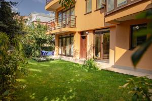 a house with a lawn in front of it at Green Oasis in the City Center in Pristina