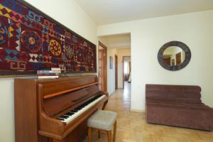 AM Apartments 1 في يريفان: غرفة معيشة فيها بيانو ومرآة