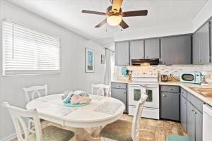 a kitchen with a table and a ceiling fan at Beachy Getaway - Cozy and Secluded Lodge Home in Knightdale