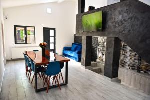 una sala da pranzo con tavolo e camino di UpForest Guesthouse a Călimăneşti