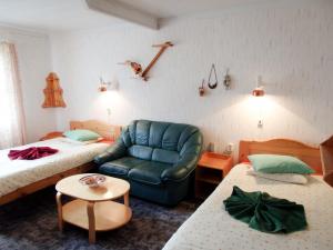 a hotel room with two beds and a blue couch at Sõrve Holiday Home in Kargi
