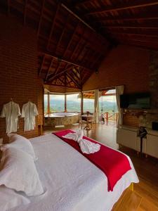 a bedroom with a large bed in a room with windows at Chalé Pico da Mantiqueira in Sapucaí-Mirim +34 photos