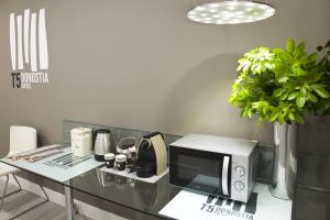 a kitchen with a counter top with a microwave at Pensión T5 Donostia Suites in San Sebastián