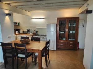 een keuken met een tafel en stoelen en een koelkast bij Los Pozos de la Nieve in Constantina