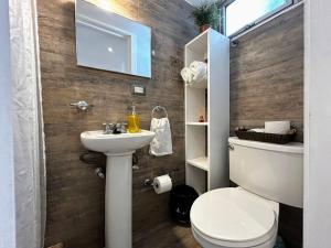 a bathroom with a toilet and a sink at Urban Shelter, El Dorm. in Guatemala