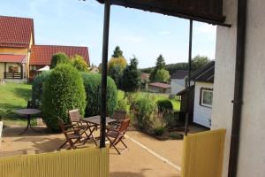 a patio with a table and chairs in a yard at Ferienhaus „Casa Lore“ in Frankenheim
